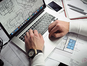 Person looking at building plans on computer.