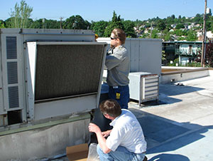 People working on an older HVAC system.