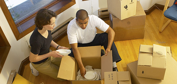 Two people packing moving boxes.